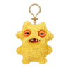 A yellow, fluffy plush monster with large orange eyes and a toothy grin attached to a keychain.