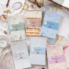 A collection of vintage scrapbook paper and craft materials including textured papers, glue, and tools.