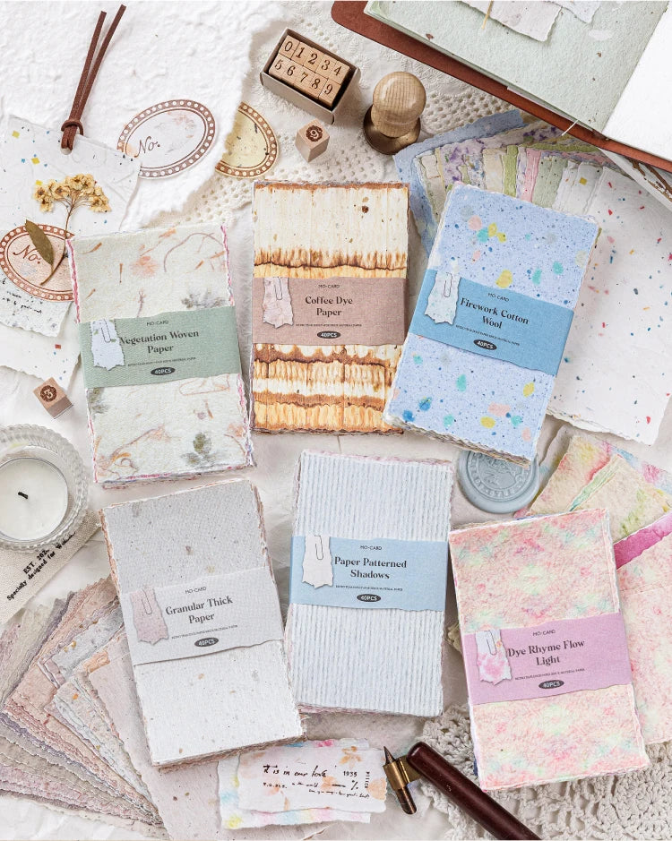 A collection of vintage scrapbook paper and craft materials including textured papers, glue, and tools.