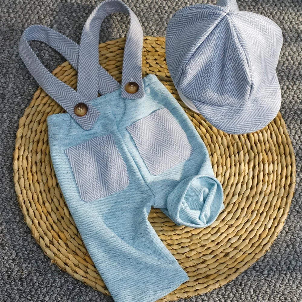 A light blue knit romper and matching newsboy cap set resting on a woven mat.