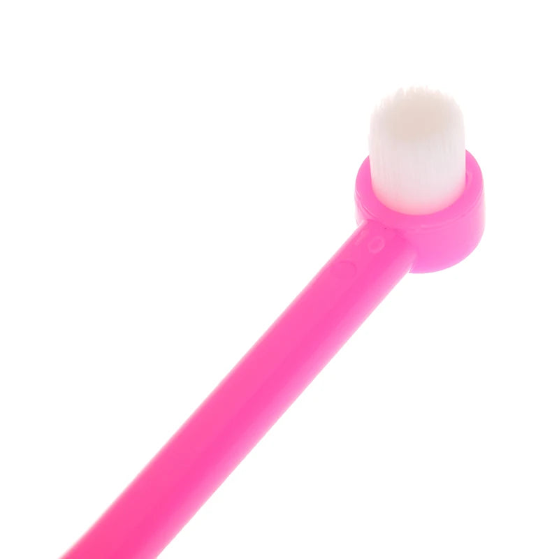 A pink orthodontic interdental brush with a white soft bristled head.