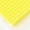 A close-up of a bright yellow, ridged polymer clay block resting on a white surface.