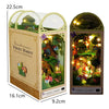 A wooden book nook kit featuring a miniature forest scene with trees and foliage.
