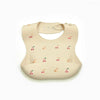 A beige soft silicone waterproof baby bib with an adjustable neck and small fruit graphics.