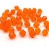 A pile of small, faceted orange crystal glass beads for jewelry making.