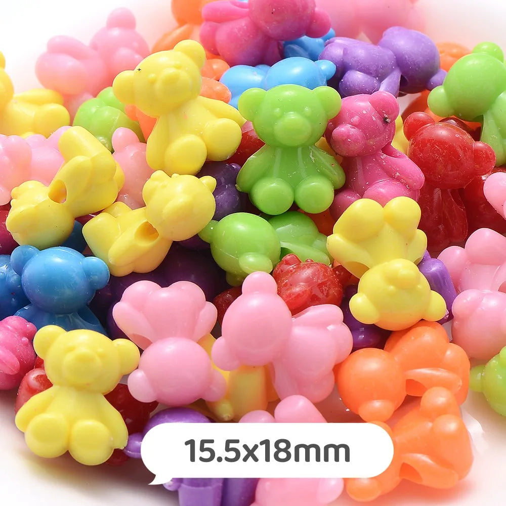 A close-up of colorful pastel bear-shaped acrylic craft beads in various shades of pink, yellow, green, and purple.