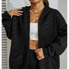 A model wears a black oversized zip-up hoodie over a white top and dark pants.