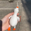 A white duck stress ball fidget toy is held in a hand, showing its size and features.