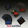 A collection of red and blue playing cards, including a deck and individual cards, displayed on a dark surface.