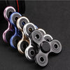 A collection of colorful aluminum alloy fidget spinners arranged in a line against a dark background.