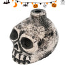 A ceramic Aztec skull whistle with a textured, weathered finish and decorative Halloween-themed string above it.