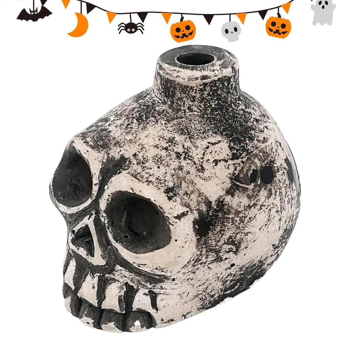 A ceramic Aztec skull whistle with a textured, weathered finish and decorative Halloween-themed string above it.