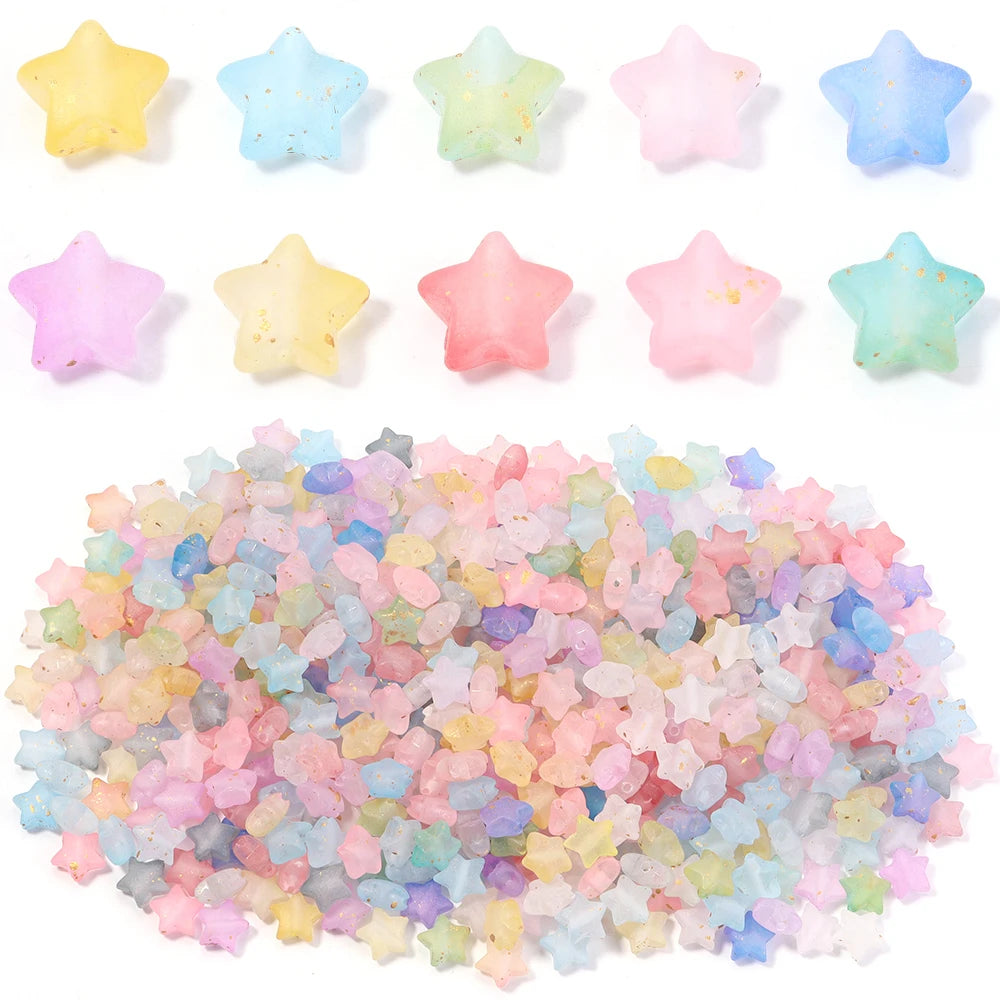 A collection of colorful transparent star acrylic beads in various pastel shades scattered across a white background.