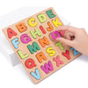 A wooden alphabet puzzle set with colorful letters A through Z is being held by a hand.