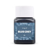 A dark blue-grey textile fabric dye kit in a white cap and glass jar.