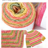 A ball of gradient rainbow yarn showing various shades of pink, orange, yellow, and green fibers.