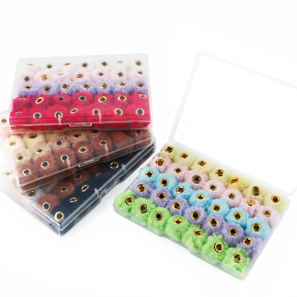 A collection of 35 plush fur pom pom beads in various colors like pink, purple, and red, packaged for jewelry making.
