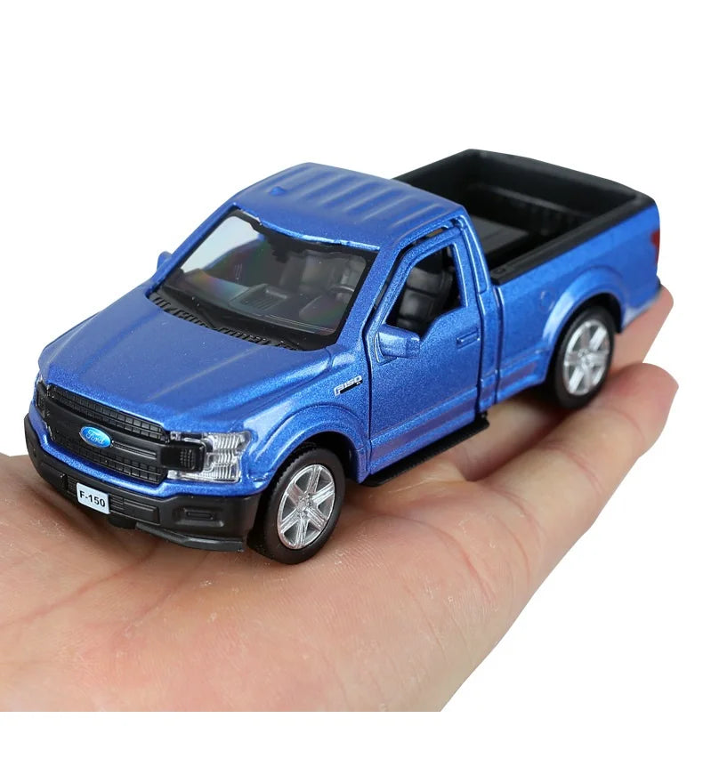 A blue Ford F-150 SVT Raptor 1:36 diecast model truck being held in a hand.
