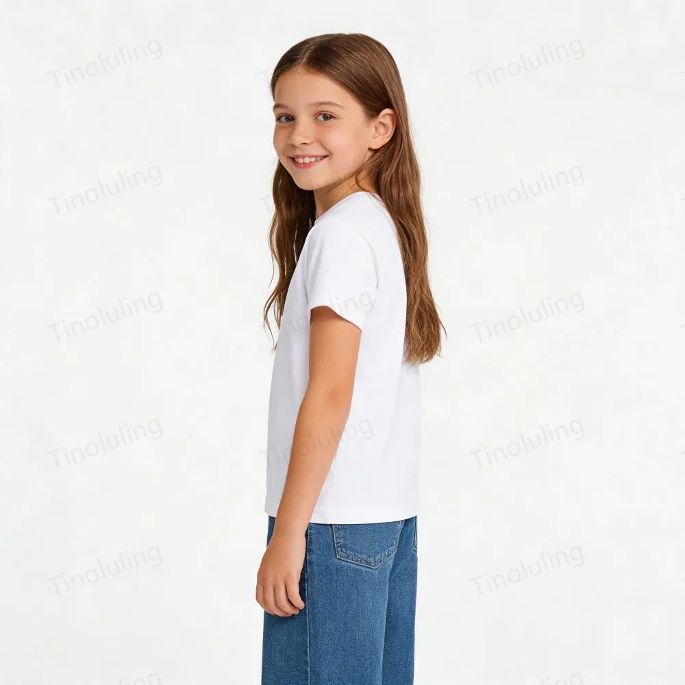 A smiling girl wearing a white short-sleeved t-shirt and blue jeans.