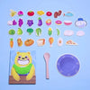 A collection of colorful, food-shaped wooden pieces for a Montessori feeding game, including fruits, vegetables, and meats.
