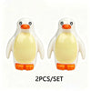 A set of two white and orange marine animal building blocks, resembling penguins or seals.