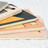 A stack of wooden geometric brain teaser puzzles in various colors like orange, yellow, and pink.