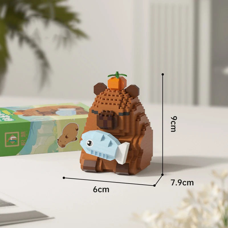 A brown capybara building block model kit with an orange fruit on top, shown next to its packaging.