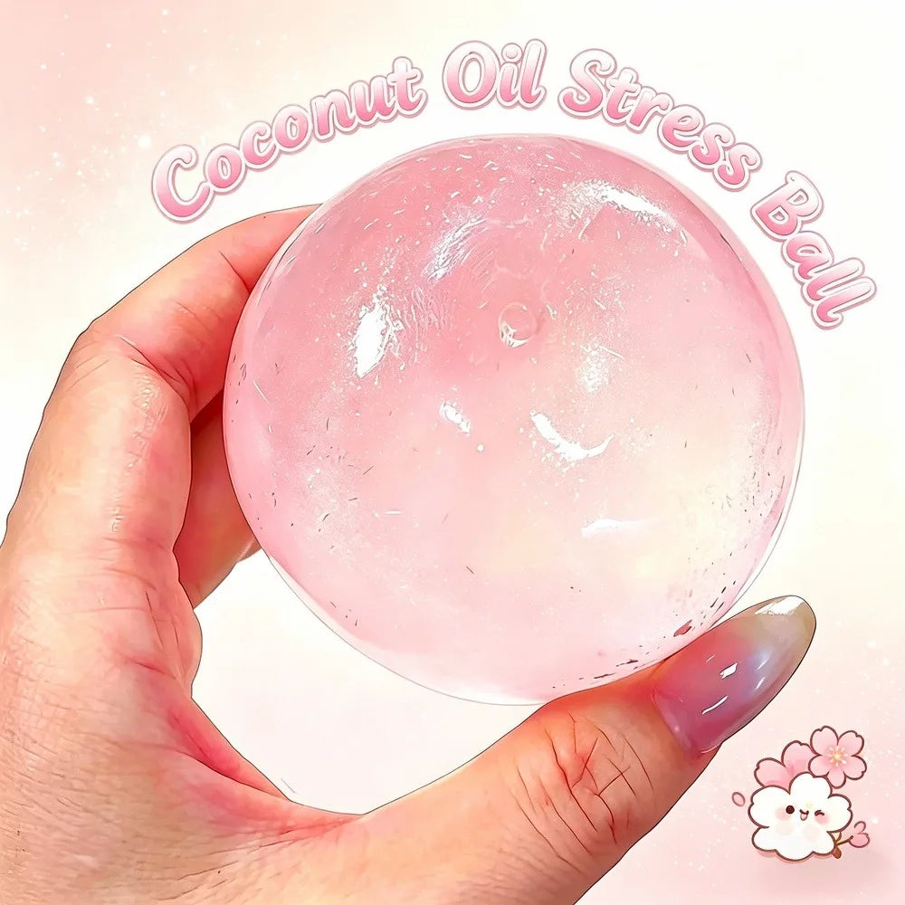 A hand holds a clear pink coconut oil stress ball, showing its smooth texture and spherical shape.