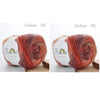 A ball of hand-dyed rainbow merino wool yarn in shades of red and orange, shown from the side.
