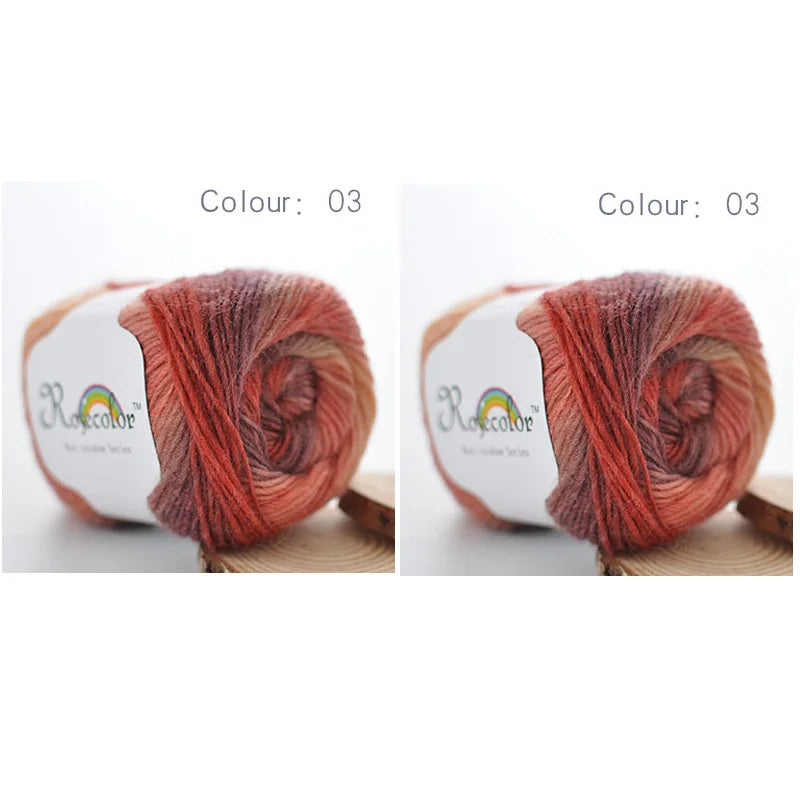 A ball of hand-dyed rainbow merino wool yarn in shades of red and orange, shown from the side.