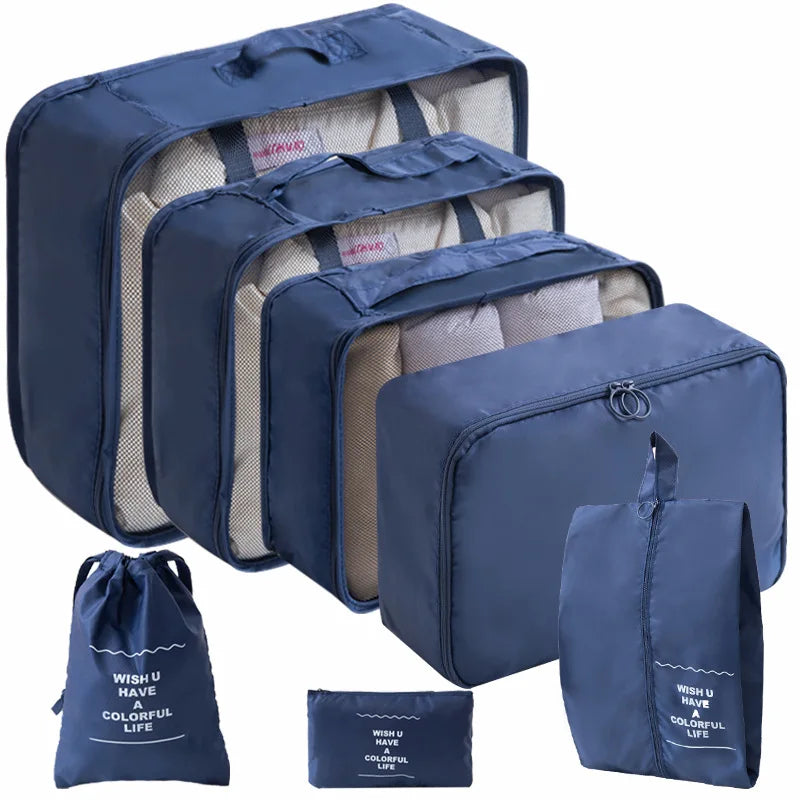 A set of navy blue travel packing cubes and a storage bag with light beige lining.