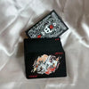 A black and white poker card deck featuring a triangular box and a card with an ornate design.