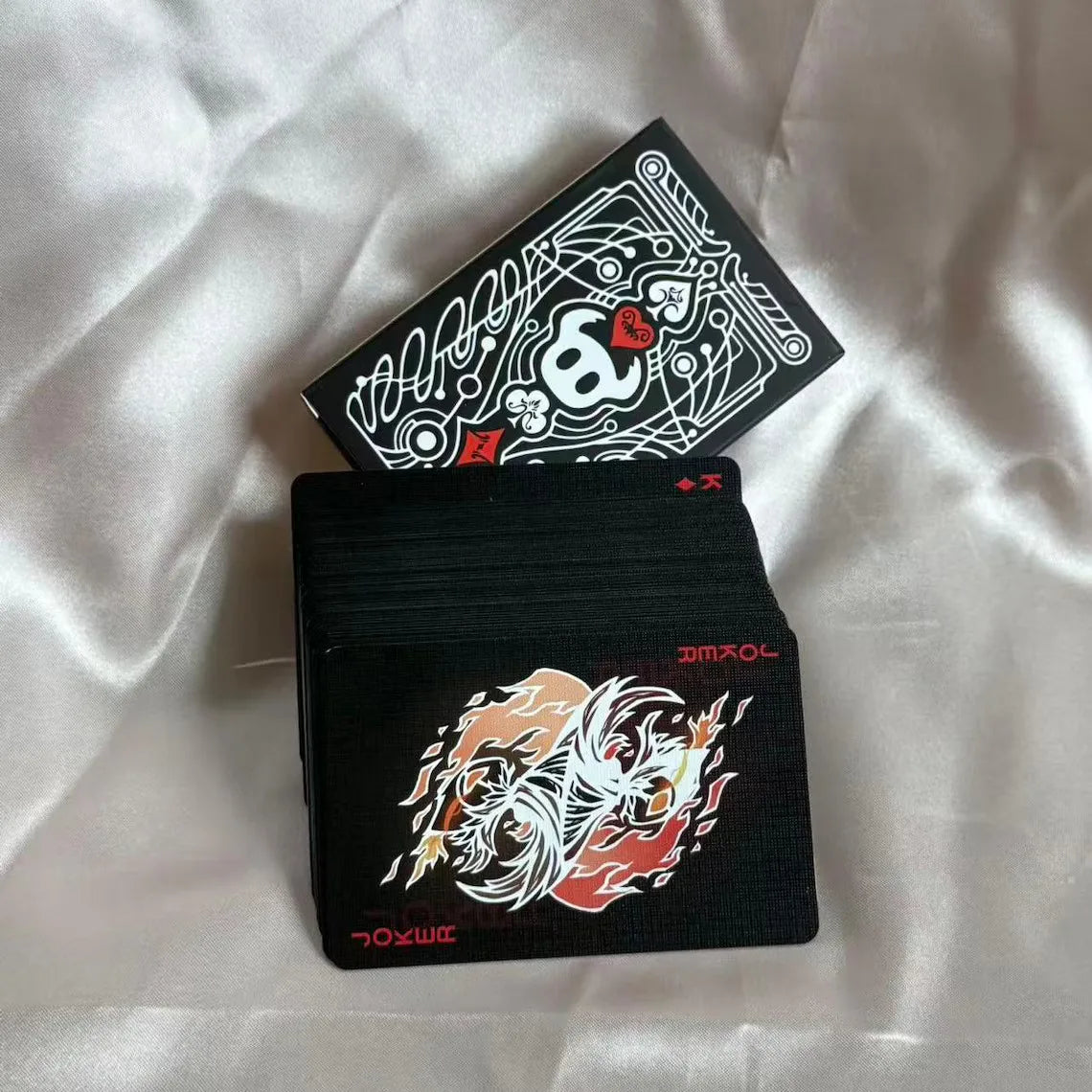 A black and white poker card deck featuring a triangular box and a card with an ornate design.