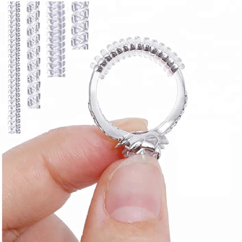 A hand holds a transparent ring size adjuster set, showing the adjustable ring and various sizes.