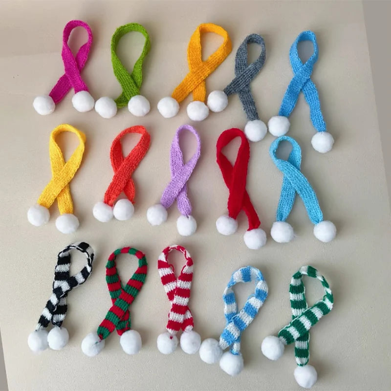 A collection of colorful mini knit Christmas hats and scarves in various colors like pink, green, yellow, orange, blue, and r
