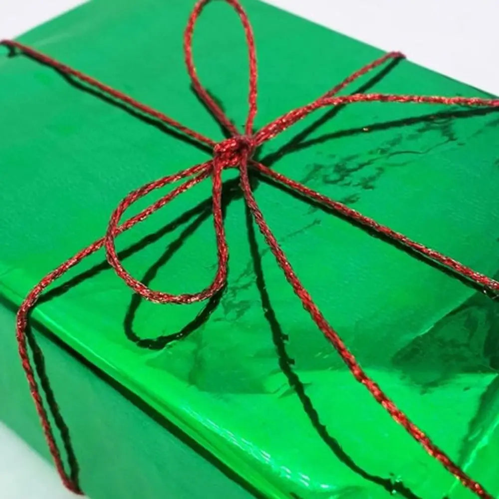 A vibrant green gift box tied with a thin red yarn string.