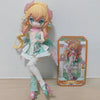 A light pink and white articulated ball-jointed doll with long blonde hair and pink accents standing next to its packaging bo