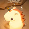 A cute white unicorn silicone LED night light illuminating a surface, showing battery capacity and usage time.