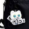 A white cat plush toy with blue eyes and a gray face is attached to a black backpack strap.