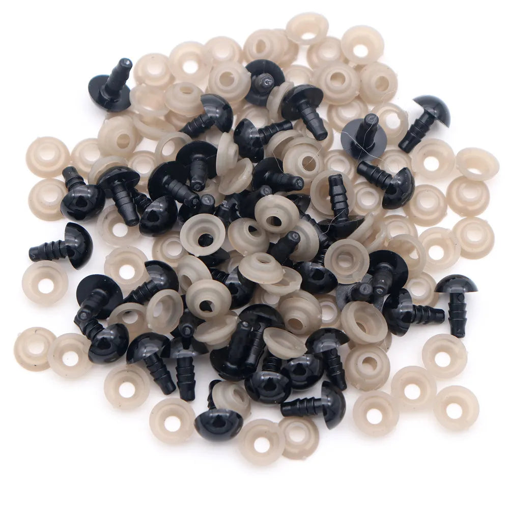 A pile of plastic safety eyes for amigurumi, featuring black and translucent/cream colored locking washers.