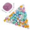 A collection of colorful sensory play sand beads in various shades of pink, blue, yellow, and white.