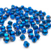 A pile of small, faceted blue crystal glass beads for jewelry making.