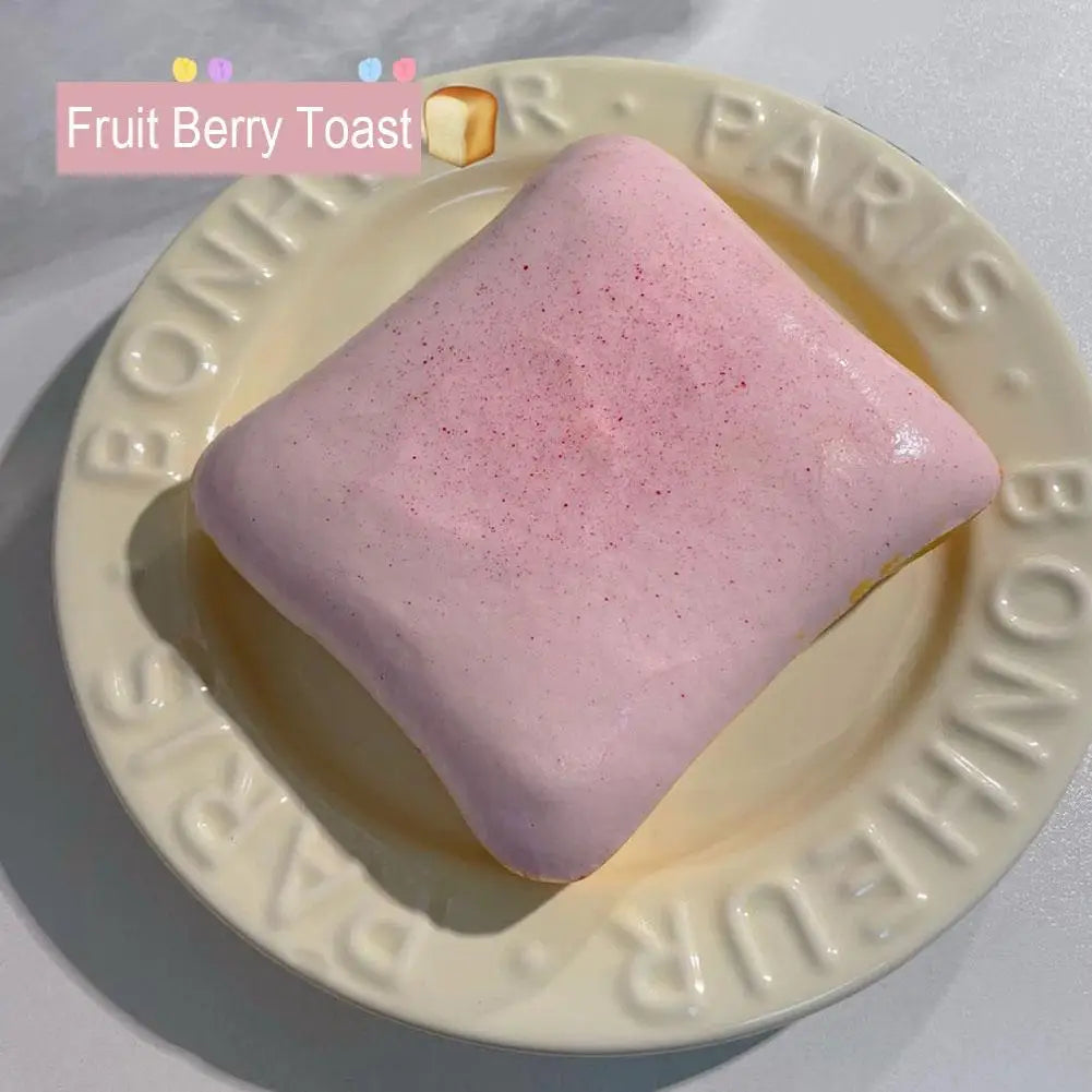 A pink Fruit Berry Toast squishy toy resting on a light yellow plate.