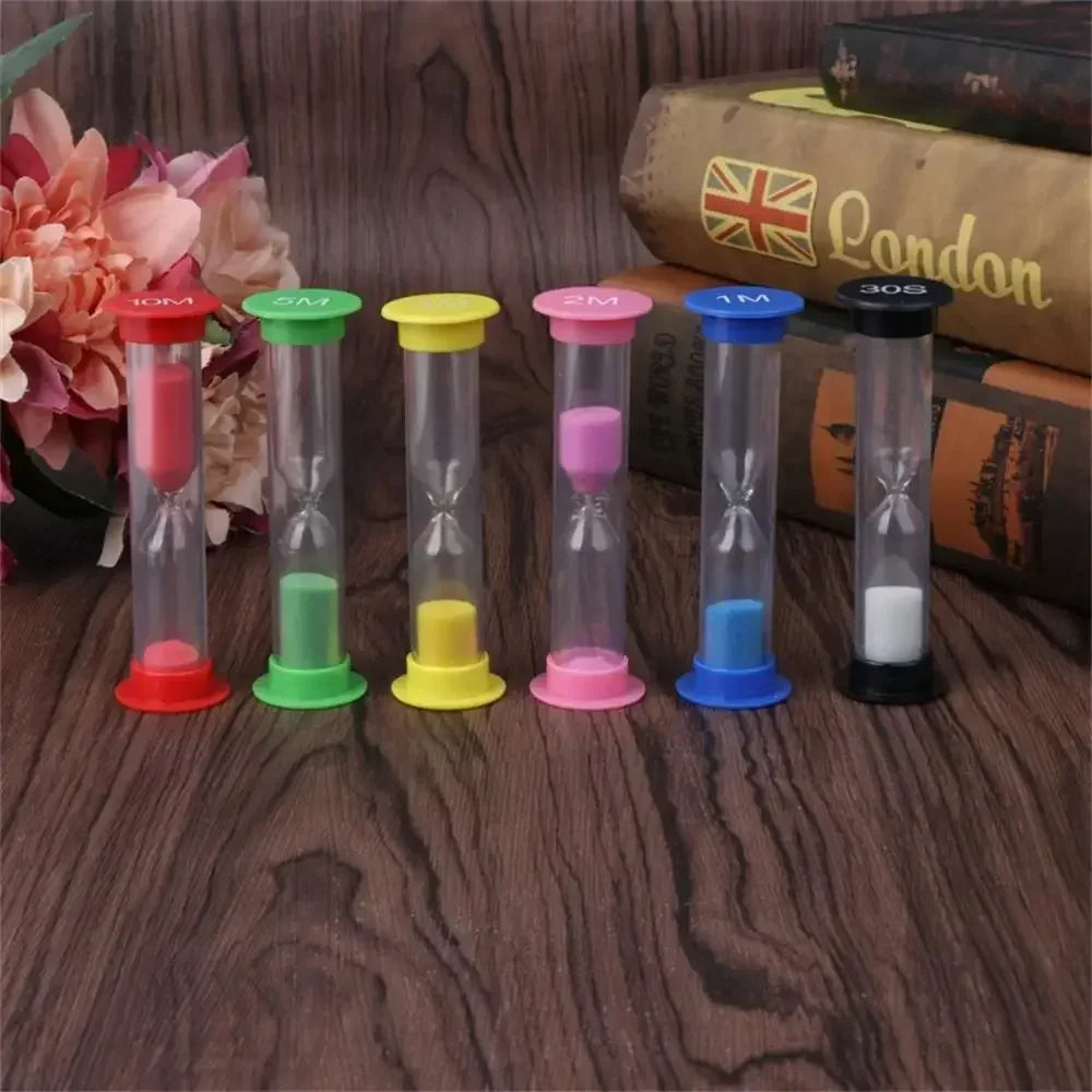 A set of six colorful hourglass sand timers with different durations and colored bases resting on a wooden surface.