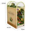 A wooden miniature bookshelf book nook kit featuring a diorama of a firefly forest with integrated LED lights.