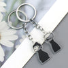Silver keychain with a black charm featuring an anime-style face and hand print.