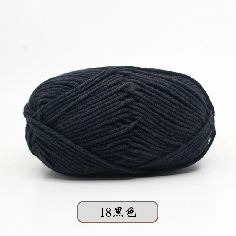 A ball of black pre-dyed milk cotton yarn for knitting and crochet.