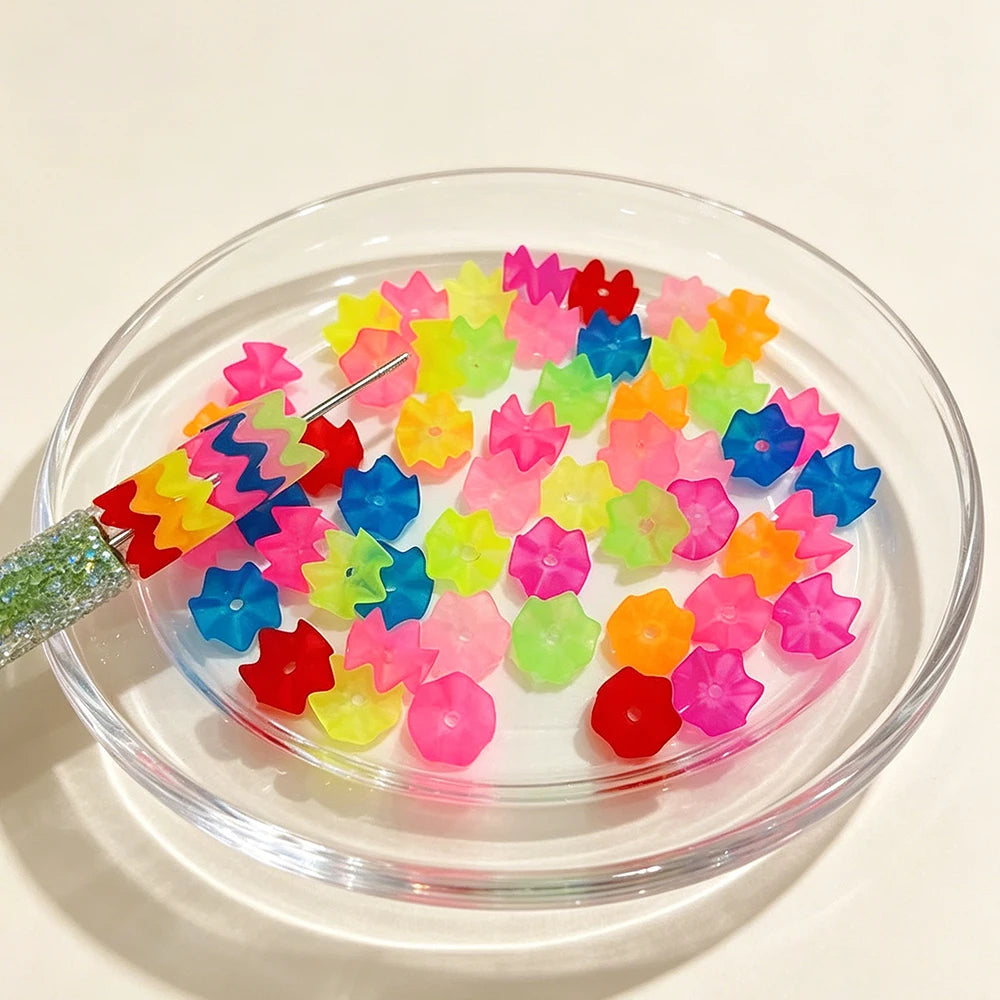 A clear glass bowl filled with 300 pieces of matte stacked translucent beads in various bright colors for jewelry making