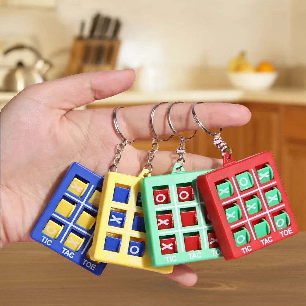 A hand holds a set of mini Tic Tac Toe keychain puzzle games in various colors like blue, yellow, green, and red.