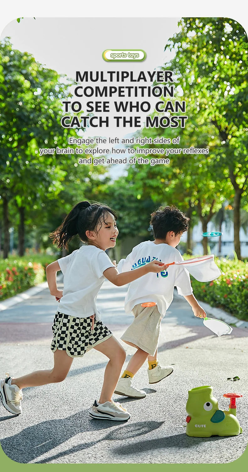Two children play a multiplayer competition using foot launchers and flying discs with catching nets in a park setting.